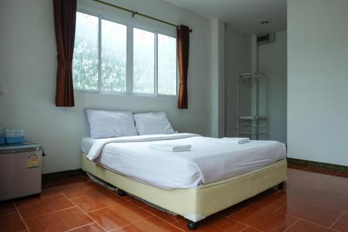 a bedroom with a bed with a window and a shower at Bai Pai Resort in Khlung