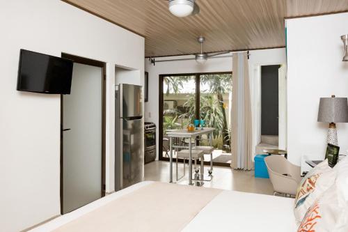 a bedroom with a bed and a kitchen with a table at Tico Tico Villas - Adult Only in Manuel Antonio