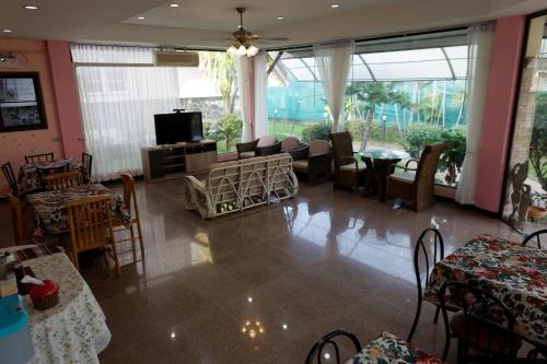 a living room with tables and chairs and a tv at TaLeKaew Resort SHA in Phitsanulok
