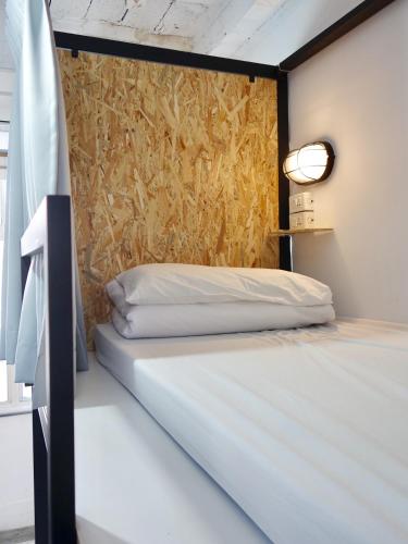 a bedroom with a bed and a wall with a painting at Old Man Captain in Tainan