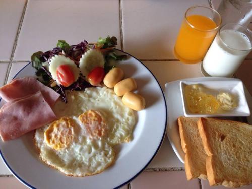 een bord ontbijtproducten met eieren en toast bij Muaklek Paradise Resort in Ban Muak Lek