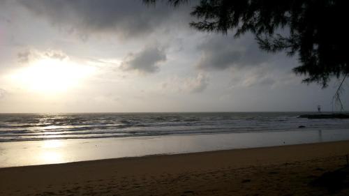 a sunset on a beach with the ocean at MJ Boutique Hotel Khao Lak in Khao Lak