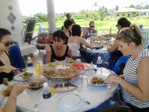 a group of women sitting at a table eating food at Taun Gusi Village Homestay in Kota Belud