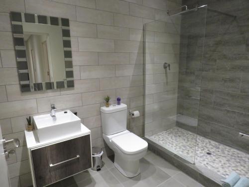 a bathroom with a toilet and a sink and a shower at The Executive - Exclusive Self-Catering Apartments - Ezulwini in Ezulwini
