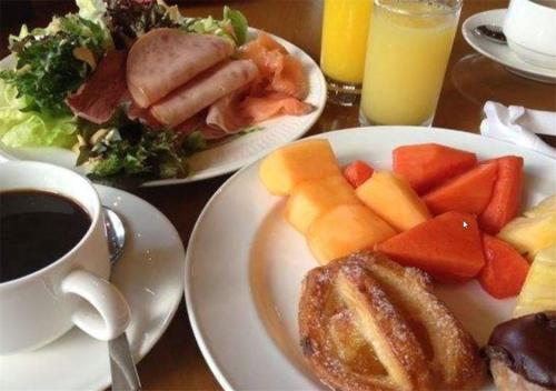 Una mesa con dos platos de comida y una taza de café. en Dalian Asia Pacific Service Apartment (Former Somerset Harbour Court Dalian), en Dalian