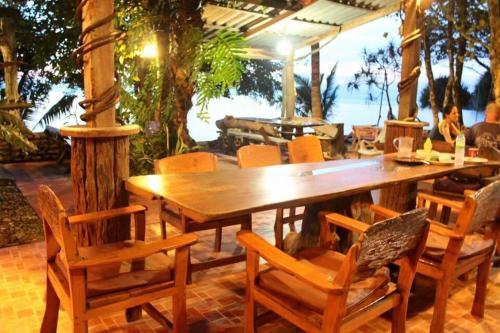 a wooden table and chairs on a patio at Sunset Bungalow Koh Chang Ranong in Koh Chang Ranong