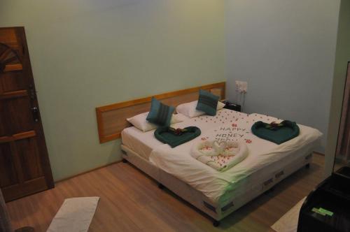 a bedroom with a bed with a heart made out of pillows at Rasdhoo Coralville in Rasdu