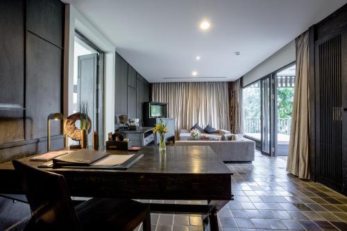 a living room with a table and a couch at Aruntara Riverside Boutique Hotel -SHA Extra Plus in Chiang Mai
