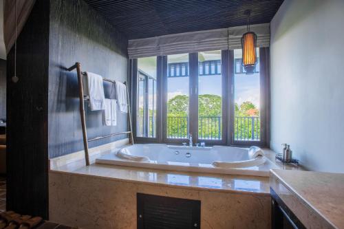 a large bathroom with a tub and a window at Aruntara Riverside Boutique Hotel -SHA Extra Plus in Chiang Mai