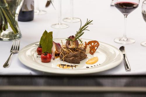 a plate of food on a table with wine glasses at Waldsee Hotel am Wirchensee in Treppeln