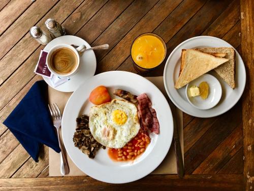 deux assiettes de petit-déjeuner sur une table en bois dans l'établissement Amore Villas, à Canggu
