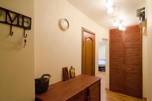 a room with a wooden desk and a clock on the wall at Tomsona Apartment Riga Center in Rīga