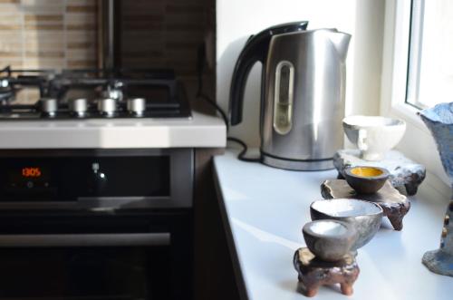 a kitchen counter with a stove and a kettle at Tomsona Apartment Riga Center in Rīga