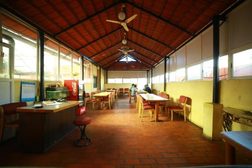 a restaurant with tables and chairs and a ceiling at Hotel Kings Kastle in Mysore