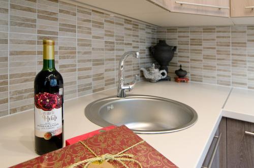 a bottle of wine sitting on a counter next to a sink at Tomsona Apartment Riga Center in Rīga