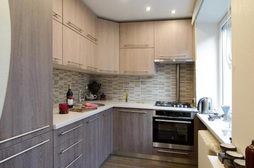 a kitchen with wooden cabinets and a stove at Tomsona Apartment Riga Center in Rīga