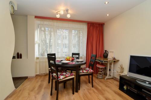 a dining room with a table and chairs and a television at Tomsona Apartment Riga Center in Rīga
