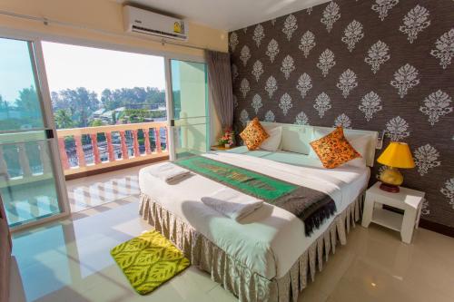 una camera con letto e balcone di Surin Sunset Hotel - SHA a Surin Beach