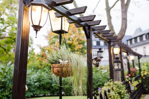 a row of lights with a potted plant in a basket at Parkhotel Krone in Bensheim