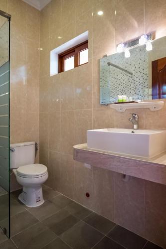 a bathroom with a toilet and a sink at Riviera Hotel & Resort Kep in Kep