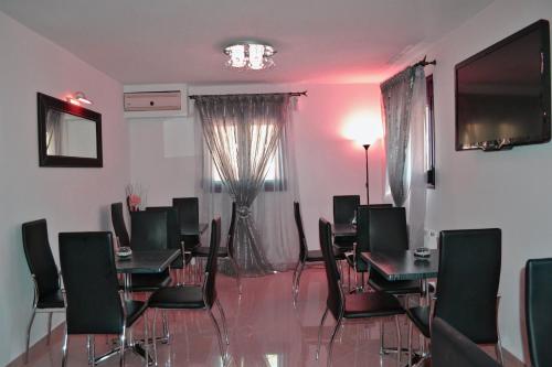 a dining room with tables and chairs and a television at Anesis in Ioannina