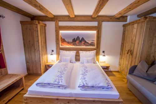 a bedroom with a bed and a painting on the wall at Mutznhof in Dobbiaco