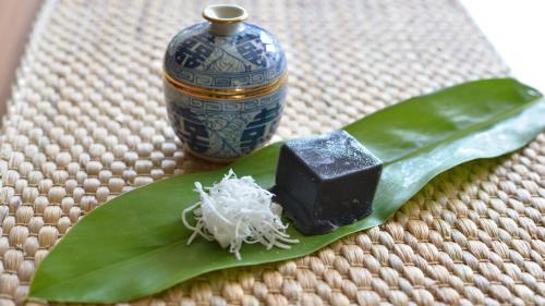 a piece of soap on a green leaf next to a vase at Trat 101 Hotel - SHA Certified in Trat