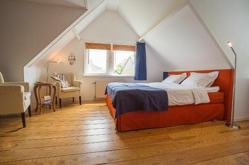 een slaapkamer op zolder met een bed en een raam bij B&B 7de Hemel in Hemelum