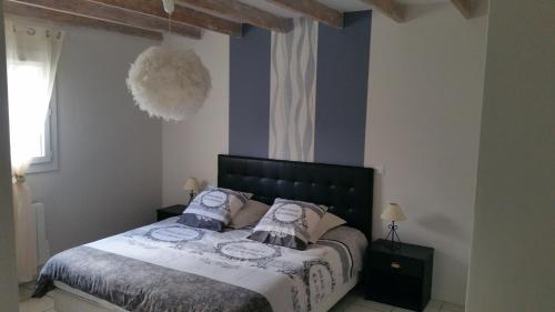 ein Schlafzimmer mit einem großen Bett mit blauen Wänden in der Unterkunft Gites Matilon, 5 min Eugénie les bains in Buanes
