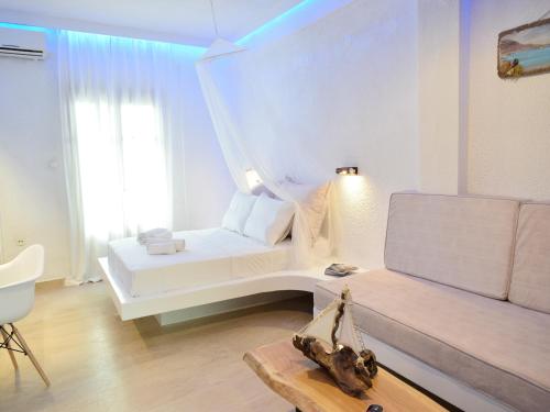 a white bedroom with a bed and a couch at Afytos Lofts in Afitos