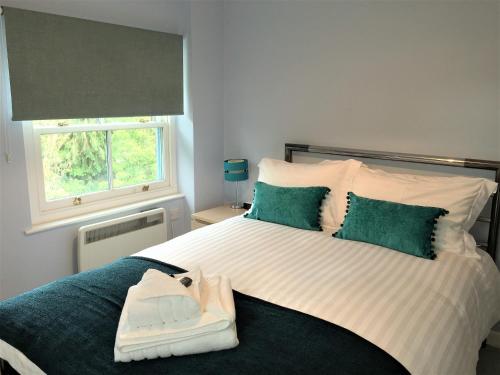 a bedroom with a large white bed with green pillows at Three Warehouse Apartments in Ulverston