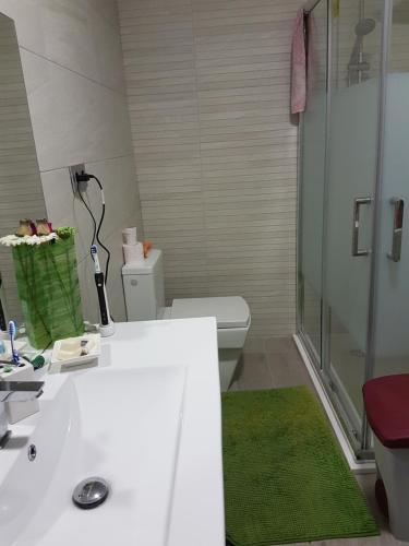 W łazience znajduje się biała umywalka i prysznic. w obiekcie Habitación en Pozuelo de Alarcón w mieście Pozuelo de Alarcón