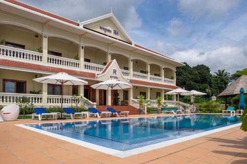 un hotel con piscina frente a él en Riviera Hotel & Resort Kep en Kep