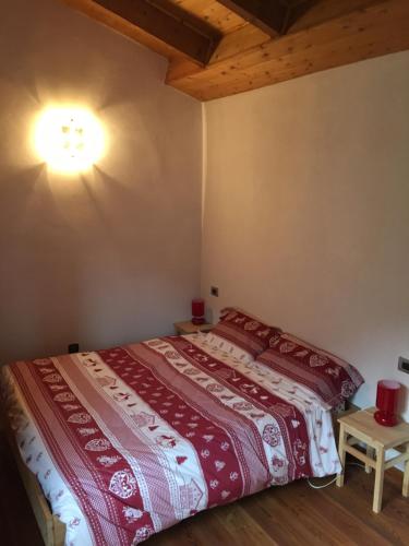 a bedroom with a bed with a red comforter at Mansarda Belvedere in Scopello