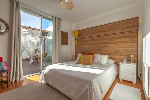 - une chambre avec un grand lit et une tête de lit en bois dans l'établissement epicenter CITY, à Ponta Delgada
