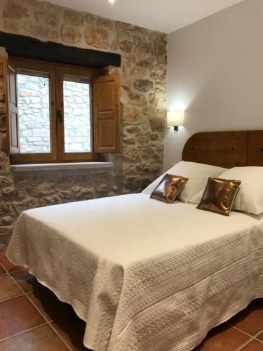ein Schlafzimmer mit einem großen Bett in einer Steinmauer in der Unterkunft Cal Triquell in El Vilosell