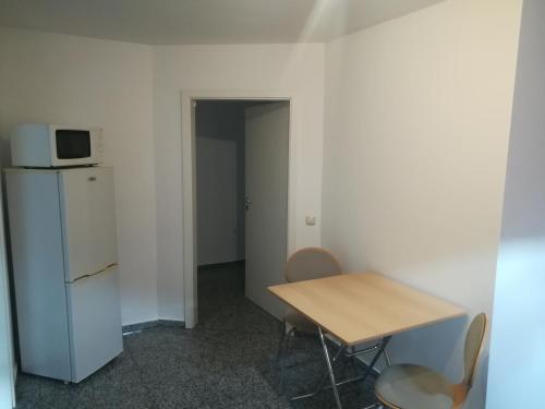 Kleines Zimmer mit einem Tisch und einer Mikrowelle. in der Unterkunft Private Apartment Ahlten in Lehrte