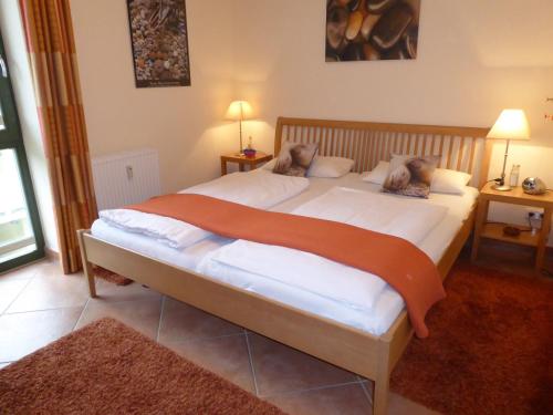 um quarto com uma cama grande e lençóis brancos em Ferienwohnung Villa Laura em Kühlungsborn