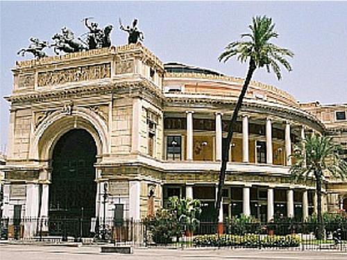 un gran edificio con una estatua encima en Casa Colorata, en Palermo