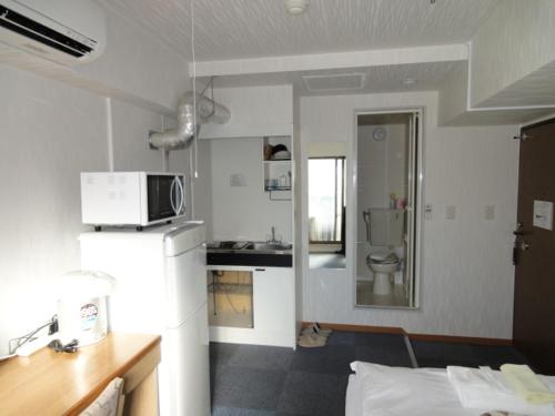 a kitchen with a white refrigerator and a sink at Soho Asakusa Hotel in Tokyo