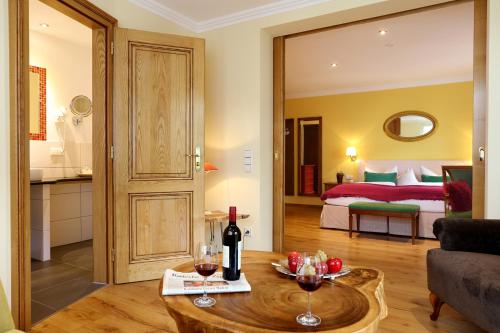 a living room with a couch and a table with wine glasses at Hotel Behringer's Traube in Badenweiler
