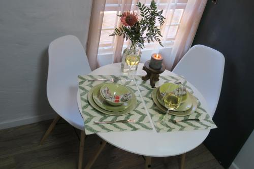 a table with plates and a vase of flowers on it at Pillow & Fern in George