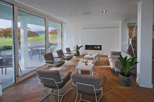 a living room with chairs and a couch and a table at Hotel Berghoeve in Epen