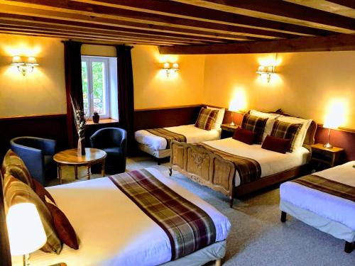 a hotel room with two beds and a chair at Chabanettes Hotel & Spa in Auzelles