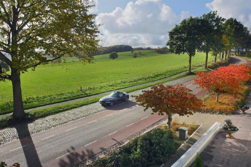 a car driving down a road in a field at Hotel Berghoeve in Epen