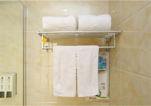 a group of towels are hanging on a rack in a bathroom at GreenTree Inn Tianjin Dasi Meijiang exhibition center Business Hotel in Tianjin