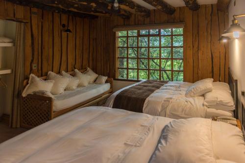 1 dormitorio con 2 camas y ventana en Hotel El Barranco, en Futaleufú