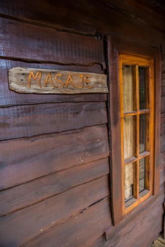 a sign on the side of a log cabin with a window at Hotel El Barranco in Futaleufú