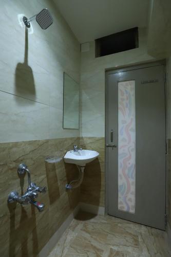 a bathroom with a sink and a mirror at Hotel Loyal Residency in Jamnagar
