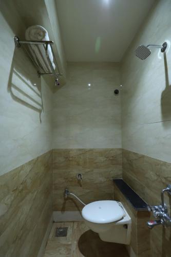 a bathroom with a toilet and a sink at Hotel Loyal Residency in Jamnagar